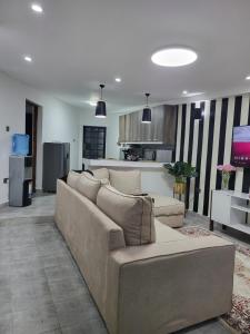 内罗毕The Akenza Cottage的客厅里有一张沙发和一个厨房