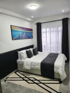 内罗毕The Akenza Cottage的卧室里有一张床，墙上挂着一幅画