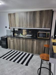 a kitchen with wooden cabinets and a stove top oven at Private 2BR Bungalow in Quiet Green Gated Estate in Nairobi