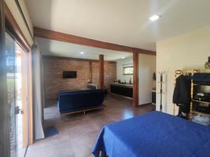 una camera da letto con un letto blu e un divano di Trilha das Siriemas a Tiradentes