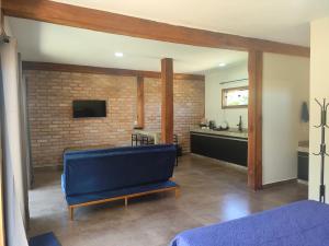 un soggiorno con divano blu e muro di mattoni di Trilha das Siriemas a Tiradentes Altre 9 foto