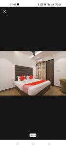 a bedroom with a large bed with red pillows at Hotel The Rudraksh inn in Indore