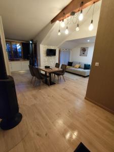 ein Wohnzimmer mit Tisch, Stühlen und Sofa in der Unterkunft Le chalet de l'amitié in Luché-Pringé