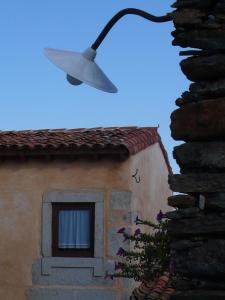 a street light attached to a building with a window at Casa da Ti Cura in Atenor