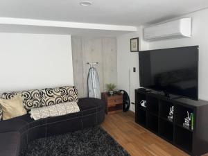 a living room with a couch and a flat screen tv at Penthouse en Centro de Monterrey in Monterrey