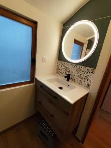 ein Badezimmer mit Waschbecken und Spiegel in der Unterkunft Le chalet de l'amitié in Luché-Pringé + 11 Fotos