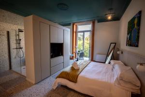 een slaapkamer met een groot bed en een badkamer bij Des Bains Acireale in Acireale