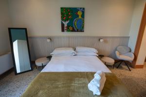 een slaapkamer met een groot bed en twee stoelen bij Des Bains Acireale in Acireale