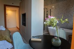 een kamer met een tafel met een vaas met bloemen erop bij Des Bains Acireale in Acireale