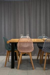 a wooden table with chairs and glasses on it at Gite Le ptit plus à Gérardmer in Gérardmer