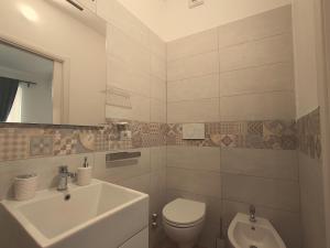 Un baño blanco con lavabo e inodoro. en MiraCivita, en Lubriano 25 fotos más