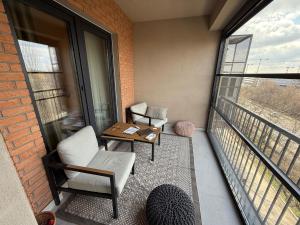 ein Balkon mit zwei Stühlen und einem Tisch und einem Fenster in der Unterkunft Baneasa Panorama Lake in Bukarest