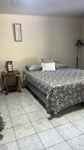 una camera da letto con un letto e un tavolo su un pavimento piastrellato di Rancho el Cocalito a La Libertad