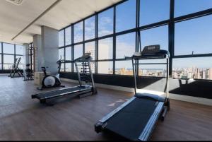 une salle de sport avec deux tapis de course et un tapis roulant dans l'établissement Max Derby 701, à Récife