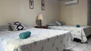 una camera con due letti con cuscini verdi di Rancho el Cocalito a La Libertad Altre 38 foto