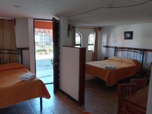 een kamer met 2 bedden en een open deur bij Villas Tonantzintla in Cholula