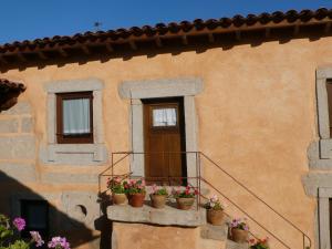 a building with potted plants on a balcony at Casa da Ti Cura in Atenor