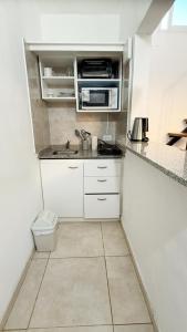 eine kleine Küche mit Spüle und Mikrowelle in der Unterkunft Dpto Low Cost Terraza Alem Costanera in Gualeguaychú