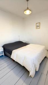 ein Schlafzimmer mit einem großen weißen Bett mit einer schwarzen Decke in der Unterkunft Dpto Low Cost Terraza Alem Costanera in Gualeguaychú