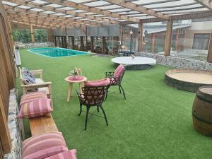 a patio with a pool and a table and chairs at Hostal Doble E Patagonia in Puerto Natales
