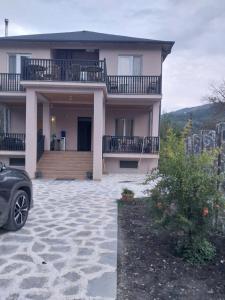 een huis met een auto ervoor geparkeerd bij Guest house Keria in Tsʼageri +8 foto's