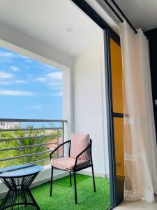 une chaise sur un balcon avec une table et une fenêtre dans l'établissement Coral Sands - BriSta Stays, à Mombasa 13 autres photos