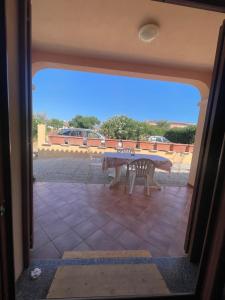 Blick auf eine Terrasse mit einem Tisch und einer Bank in der Unterkunft Casa vacanza San Teodoro in San Teodoro