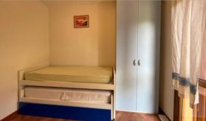 ein kleines Zimmer mit einem Bett und einem Kleiderschrank in der Unterkunft Casa vacanza San Teodoro in San Teodoro