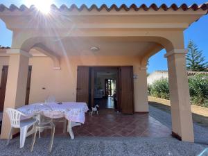 einen Tisch und Stühle auf einer Terrasse mit einem Hund in der Unterkunft Casa vacanza San Teodoro in San Teodoro