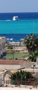 um navio de cruzeiro no oceano, próximo à praia em أراكِ قريبا صينين فقط em Marsa Matruh