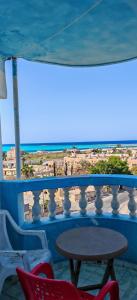 uma mesa e cadeiras em uma varanda com vista para a praia em أراكِ قريبا صينين فقط em Marsa Matruh