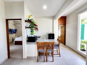 een eetkamer met een tafel en stoelen en een slaapkamer bij Hotel Otoch Apartments in Telchac