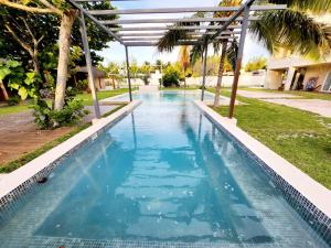 een zwembad met blauw water in een tuin bij Hotel Otoch Apartments in Telchac