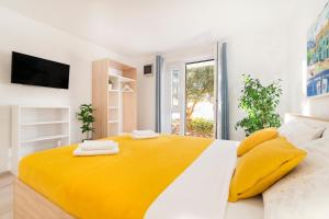 una camera da letto bianca e gialla con un letto grande di Guest House Kovacevic a Hvar