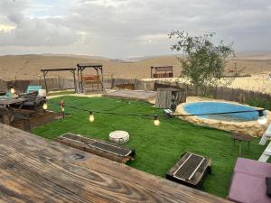 a backyard with a pool and a table and a playground at בית אירוח מרום במדבר in Dimona