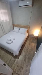 a bed with white sheets and pillows in a room at בית אירוח מרום במדבר in Dimona