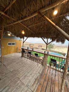 a deck with a table and chairs and a pool at בית אירוח מרום במדבר in Dimona