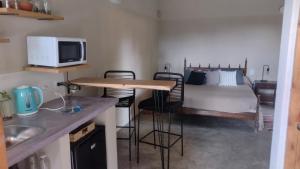 een kleine kamer met een bed en een tafel en stoelen bij La Paz suites de campo in Capilla del Señor