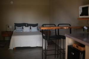 een slaapkamer met een bed met blauwe en witte kussens bij La Paz suites de campo in Capilla del Señor +3 foto's