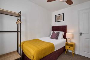 une chambre avec un lit avec une couverture jaune dans l'établissement Cornish Haven -Spacious 4 Bed House by Launceston, à Launceston