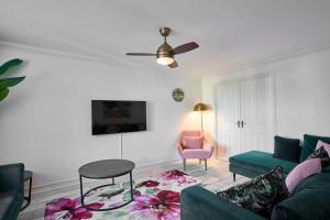 - un salon avec un canapé vert et une chaise rose dans l'établissement Cornish Haven -Spacious 4 Bed House by Launceston, à Launceston