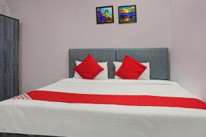 a bedroom with a large bed with red pillows at Collection O Gauri Shree Hotel in Bhopal +13 photos