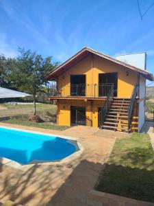 una casa con una piscina di fronte di Trilha das Siriemas a Tiradentes