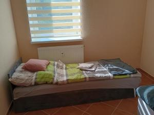 an unmade bed in a room with a window at Noclegi Sówka in Sośnina