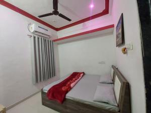 a small bed in a room with a ceiling at SOU Mahadev Homestay in Garudeshwar +4 photos