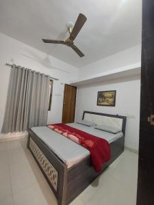 a bedroom with a bed with a ceiling fan at SOU Mahadev Homestay in Garudeshwar