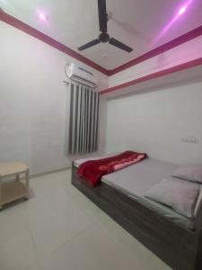 a bedroom with a bed with a ceiling fan at SOU Mahadev Homestay in Garudeshwar