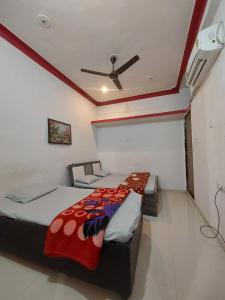 a bedroom with two beds and a ceiling fan at SOU Mahadev Homestay in Garudeshwar