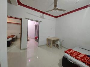 a room with two beds and a ceiling fan at SOU Mahadev Homestay in Garudeshwar