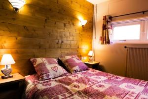 Un dormitorio con una pared de madera y una cama con almohadas. en Résidence Bero Bisto - maeva Home - Appartement vue montagne 2 pièces + coin cabine 6 personnes MAE-7633, en La Mongie